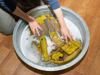 リュックサックを水槽に入れて手洗いしている写真。